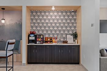 A modern kitchen with a wooden chair and a patterned wallpaper.